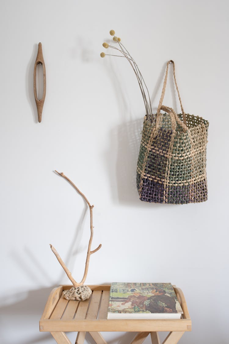 A Wicker Bag Hanging On The Wall Near A Table