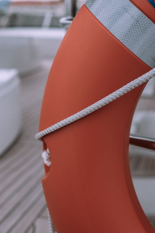 Free Detailed view of a lifebuoy and rope on the deck of a boat, emphasizing safety equipment. Stock Photo