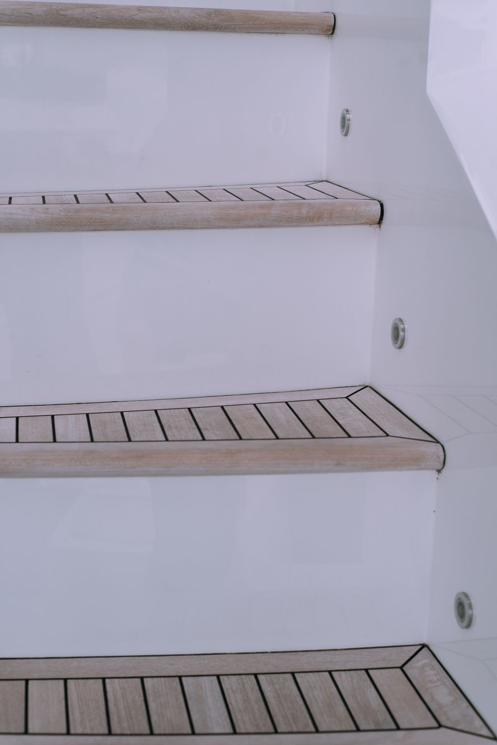 Vela companionway — teak-tread stairs leading below deck