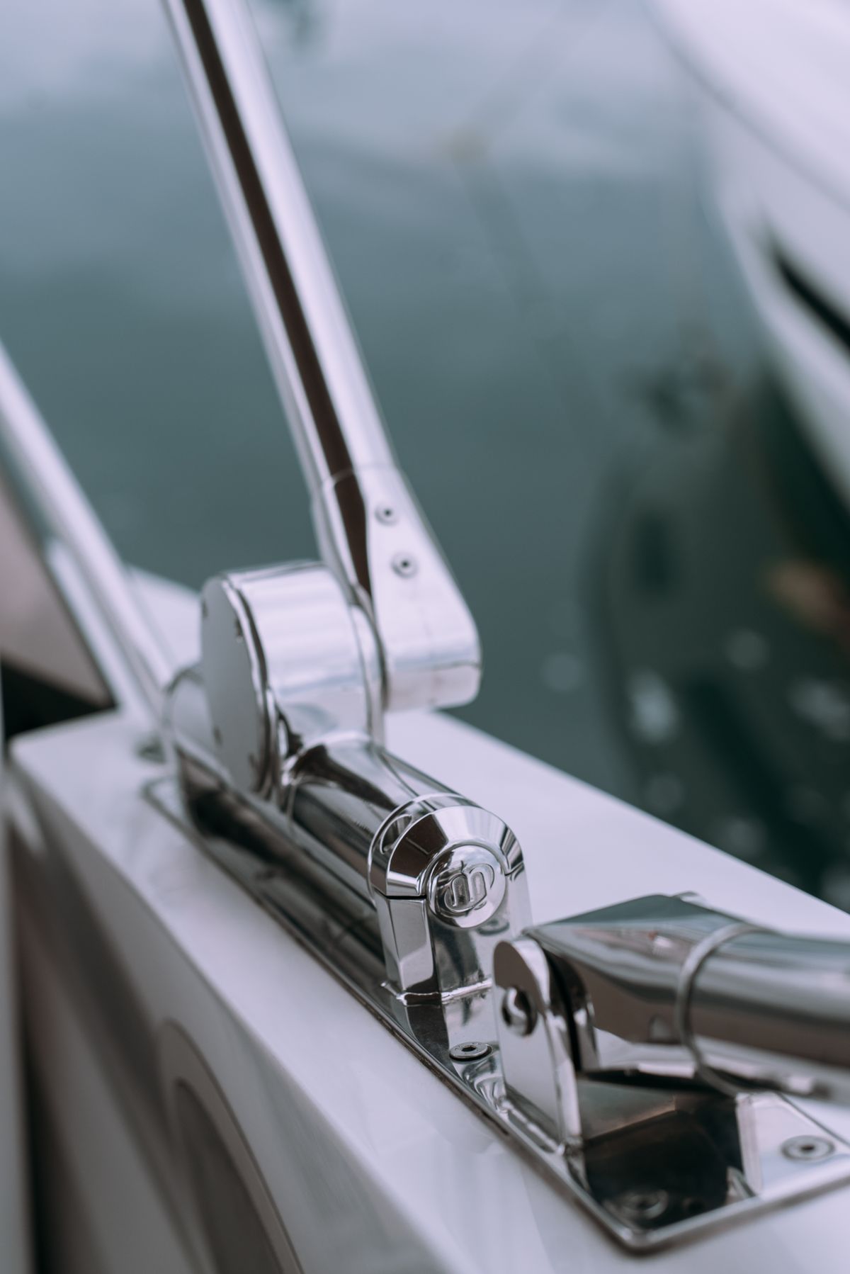 Close-up of polished boat rail hardware showing clamp clearance and round rail shape