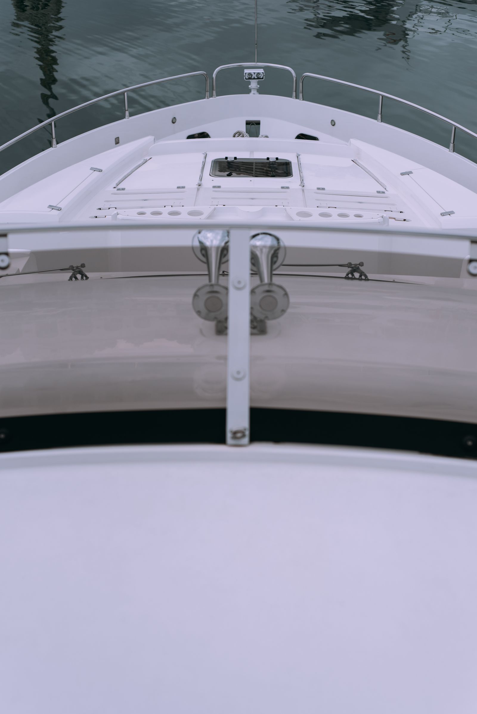 Bow of a yacht meeting calm open water, seen from above