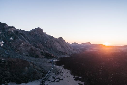 Breathtaking aerial view of rugged mountains during sunrise, showcasing natural beauty and serene landscapes.