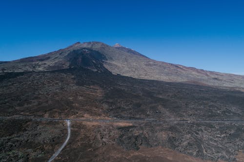 Aerial View of a Road by the Mountain and the Blue Sky