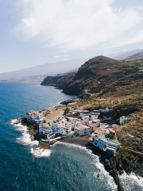 Free A picturesque aerial view of a coastal town perched on a rugged cliff by the ocean. Stock Photo