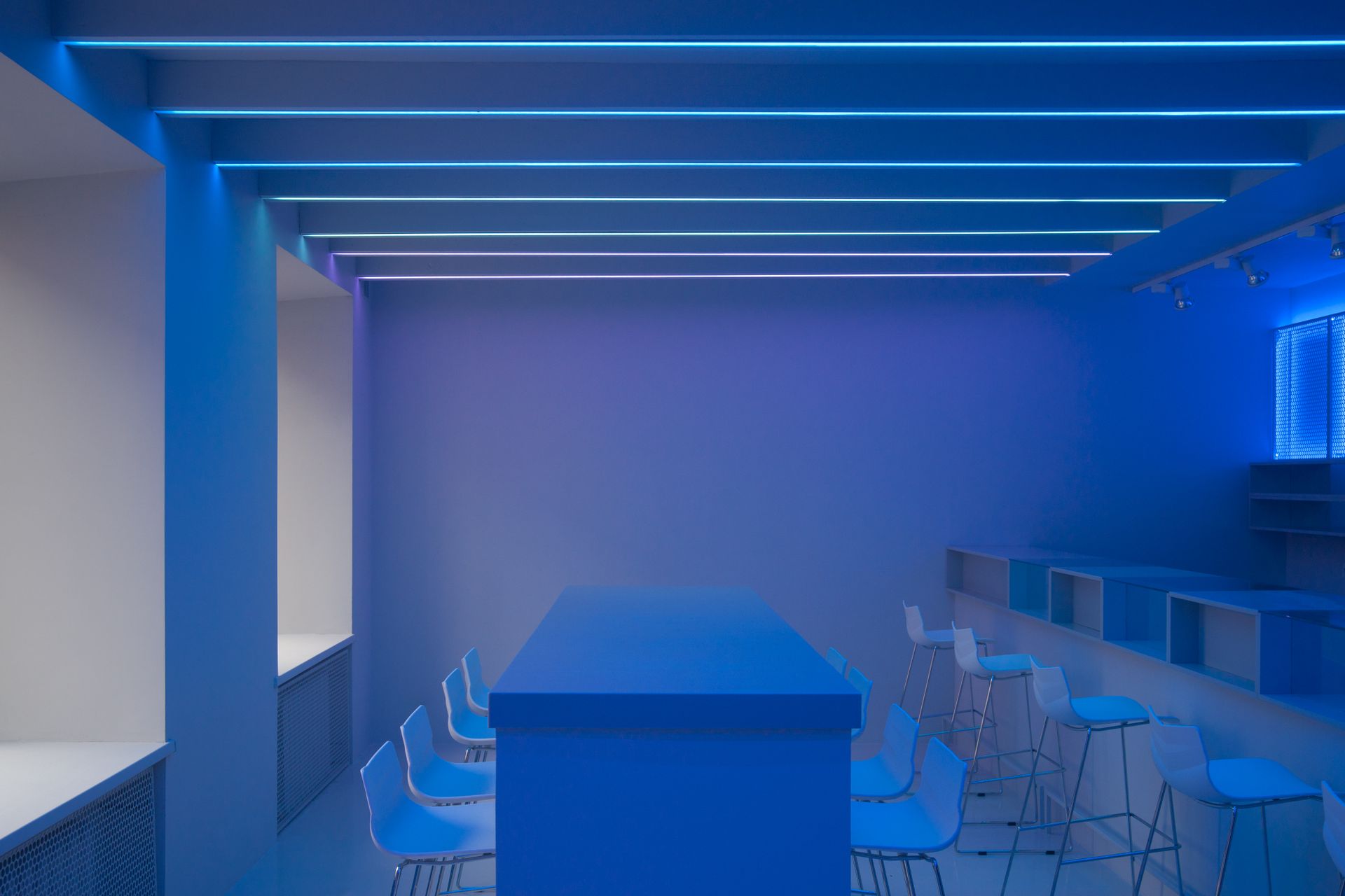 A modern minimalist interior highlighting blue tones and sleek furniture design.