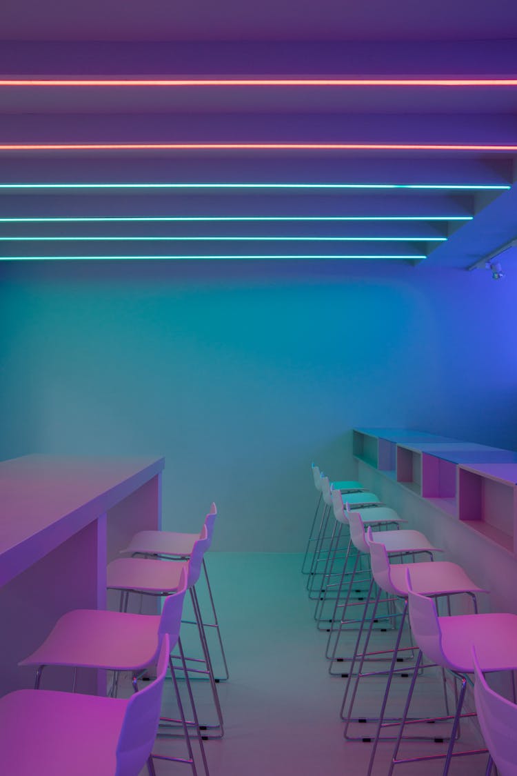 Photo Of Chairs And Tables Under Purple And Blue Lights