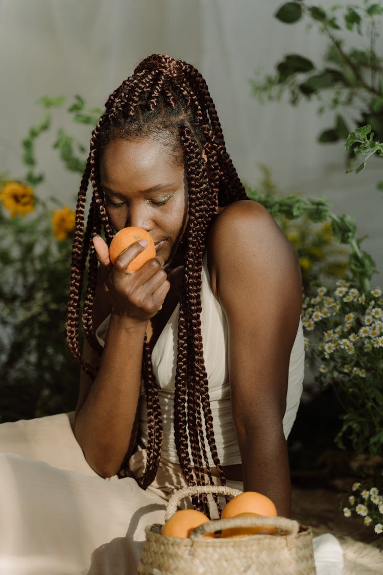 Braided Hair Woman Smelling Fruit