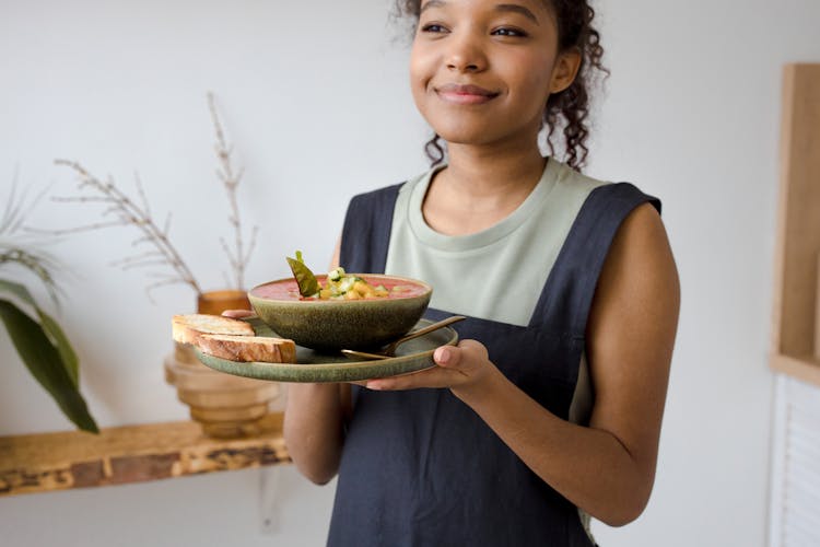 A Woman Smiling While Holding A Yummy Dish