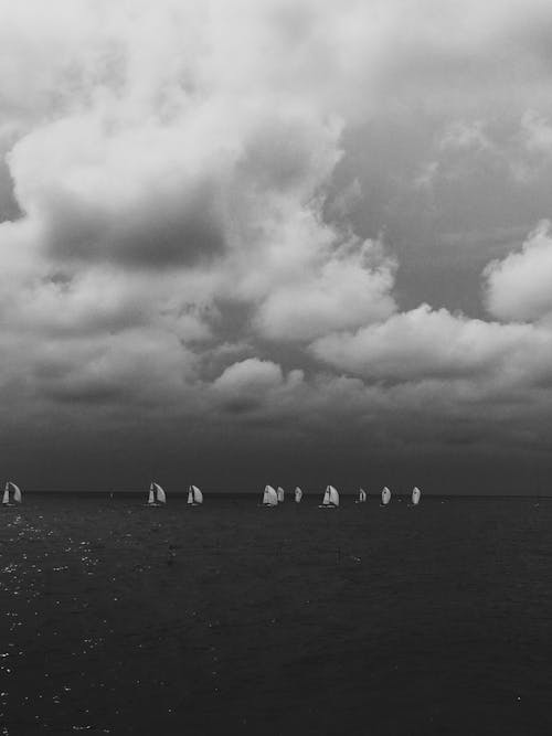 Grayscale Photo of Sail Boat on the Ocean