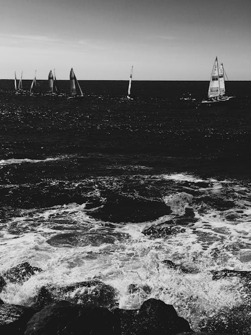 Grayscale Photo of Sailboats on the Ocean