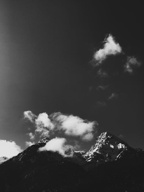 A Grayscale Photo of a Mountain Under the Dark Sky