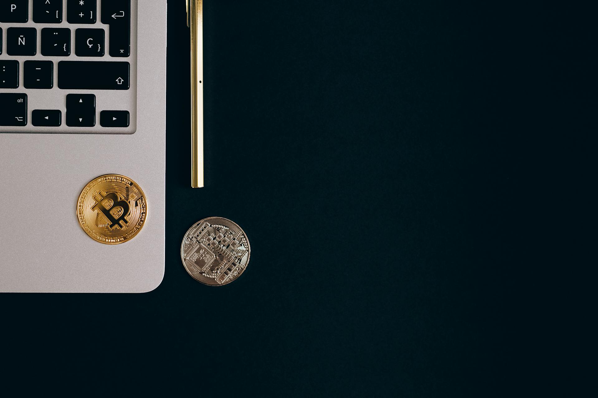 Top View of a Gold and Silver Bitcoin with Laptop