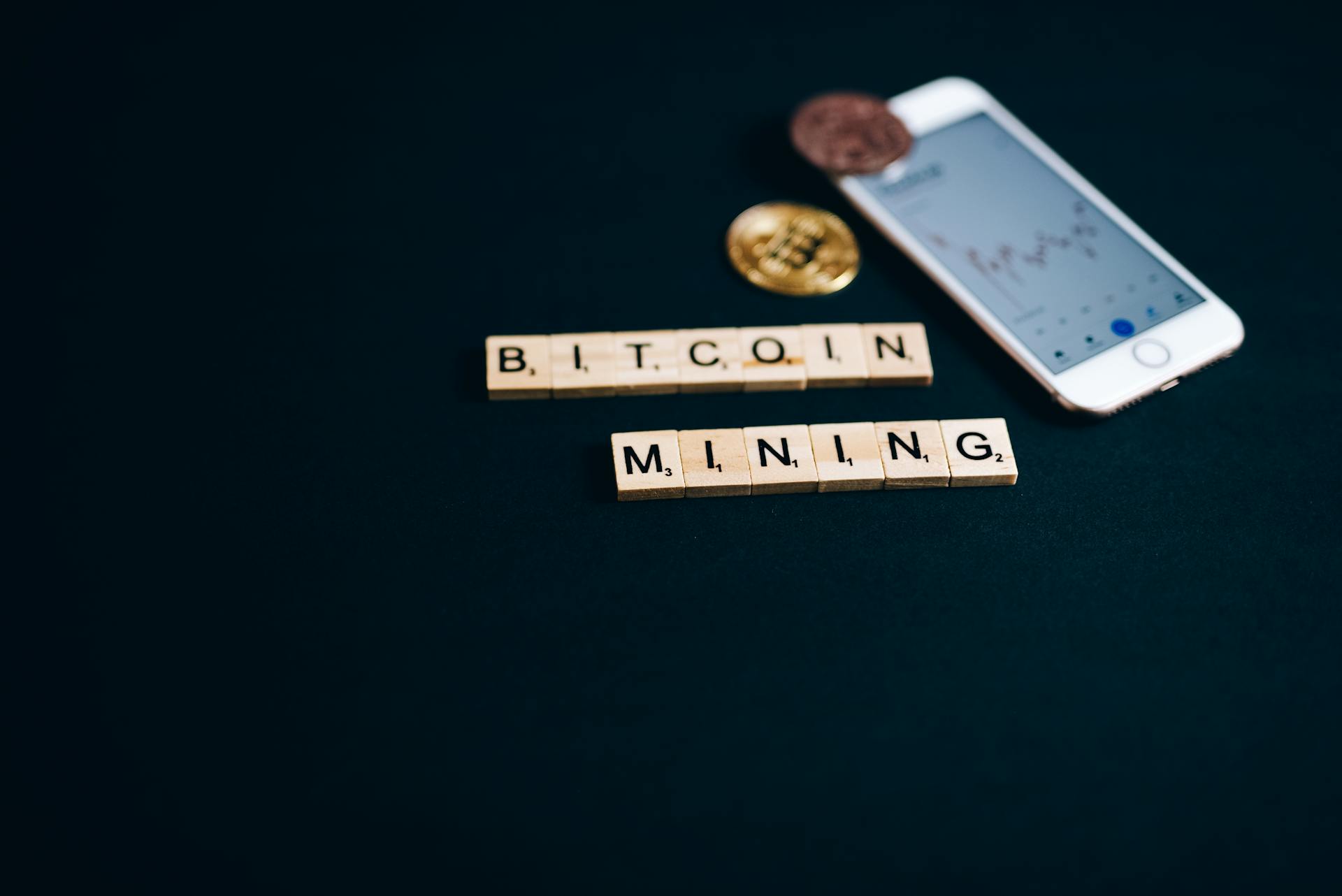 Bitcoin Mining Letter Tiles Near an Iphone