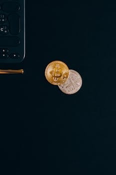 Close-up of Bitcoin and Ethereum coins beside a calculator on dark background, perfect for finance concepts.