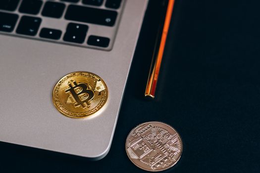 Close-up of Bitcoin and cryptocurrency coins on a laptop, symbolizing digital finance.
