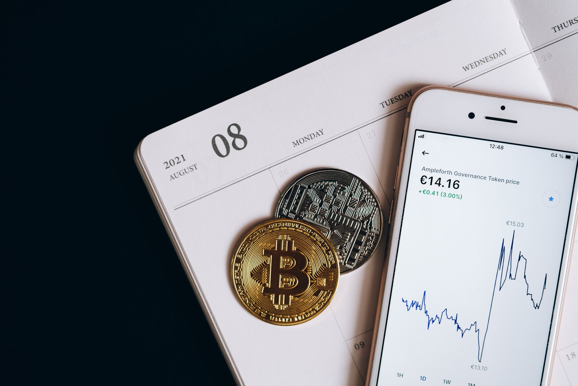 A smartphone displays cryptocurrency data alongside Bitcoin and Ethereum coins on an August calendar.