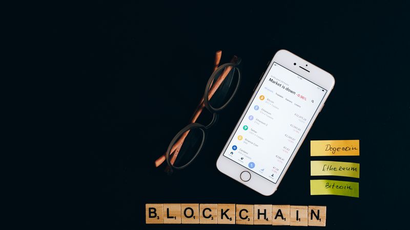 Smartphone displaying cryptocurrency market status with blockchain concept on black backdrop.