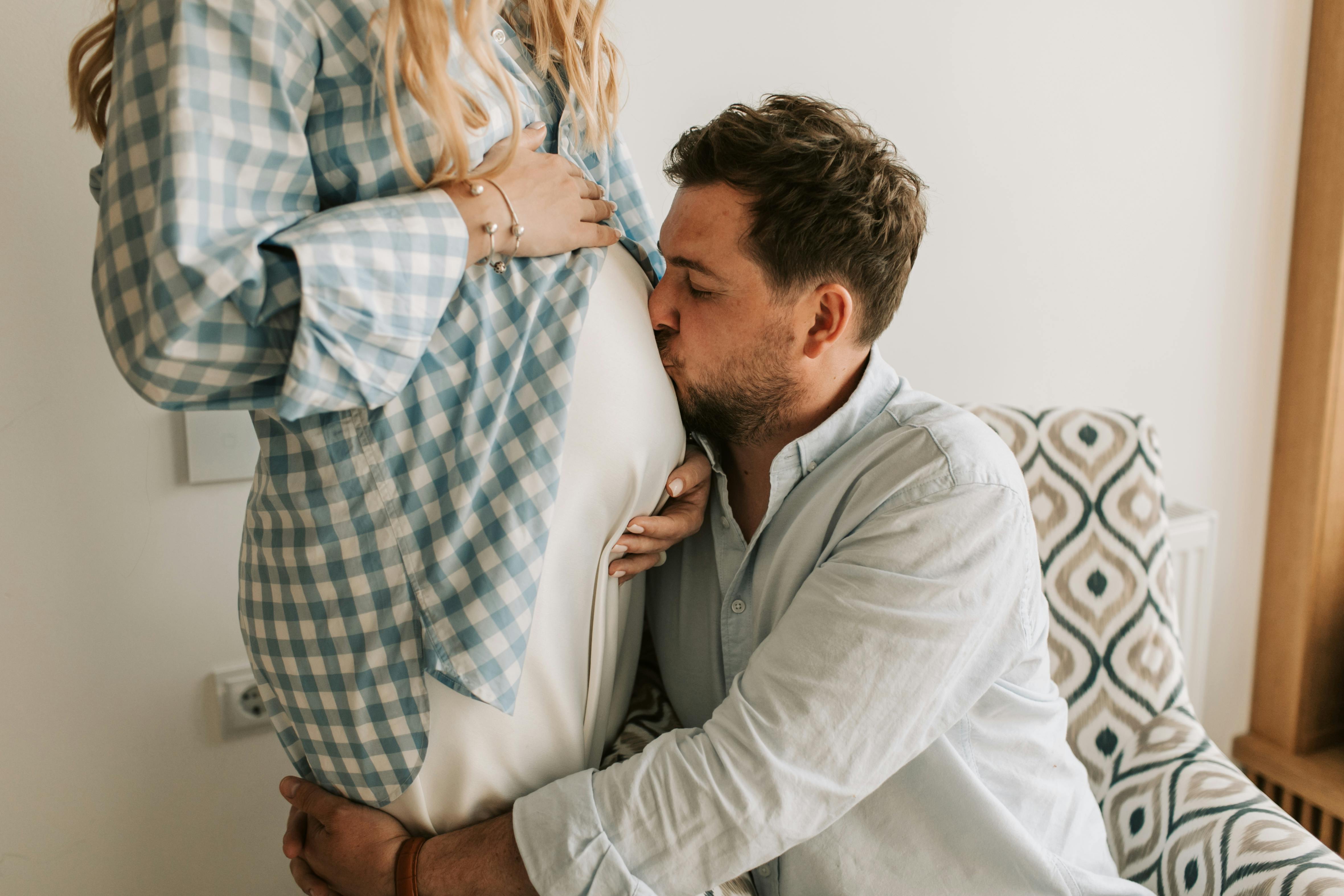 husband kissing the belly of her wife