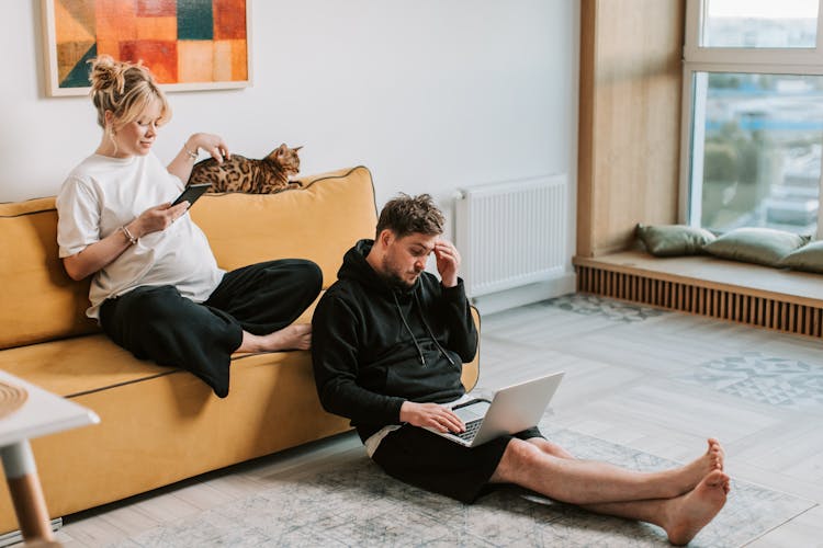 Man And Woman Using Gadgets At Home