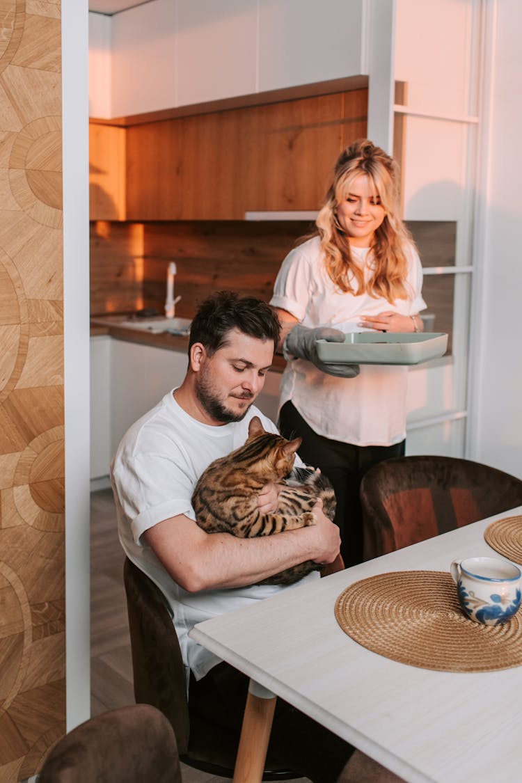 Man In White Shirt Holding A Cat At Home