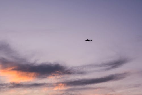 Free Silhouette of an Airplane Flying in the Sky Stock Photo