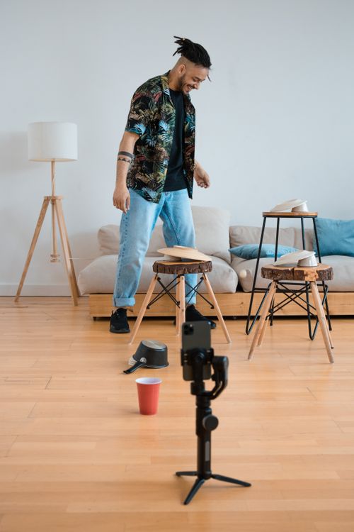 Free Creative young man filming content at home, showcasing an indoor scene with a focus on modern lifestyle. Stock Photo