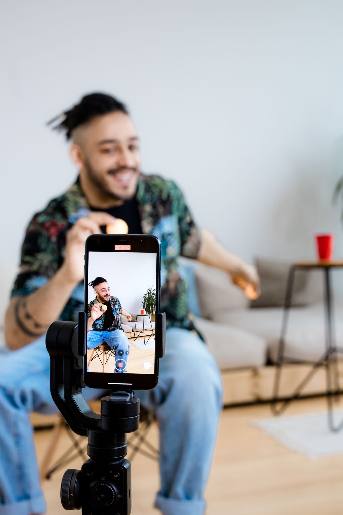 Content creator filming a product video on a smartphone mounted on a gimbal