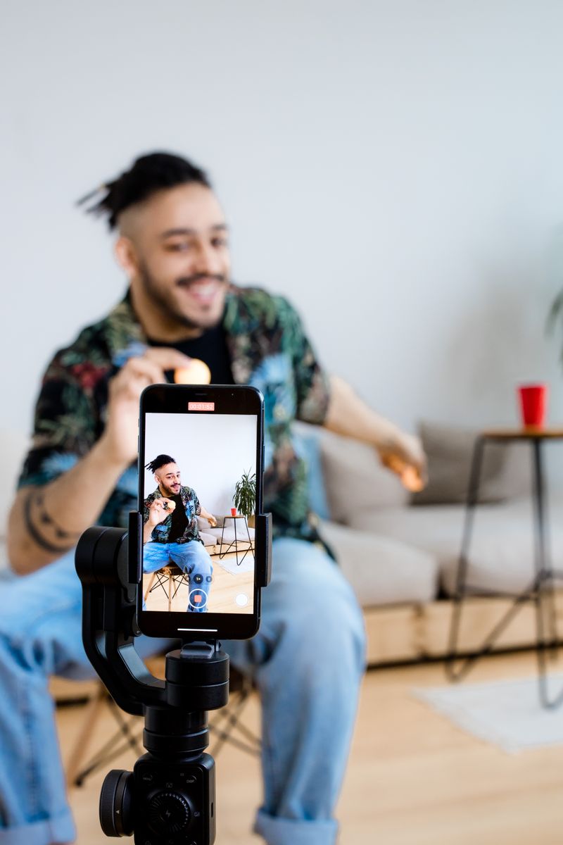 Content creator filming a product video on a smartphone mounted on a gimbal