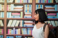 Woman Wearing V-neck Sleeveless Top Near Bookshelf