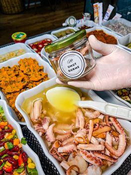 A vibrant selection of seafood and gourmet dishes displayed in ceramic containers, showcasing diverse culinary offerings.