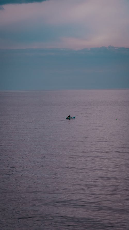 Person Riding a Boat on Sea
