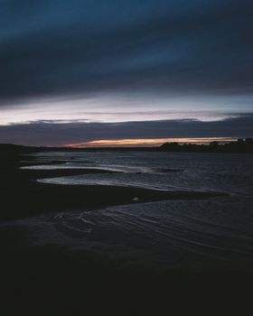 Peaceful riverbank scene at dusk with a vibrant sky in Kotel'nich, Russia.