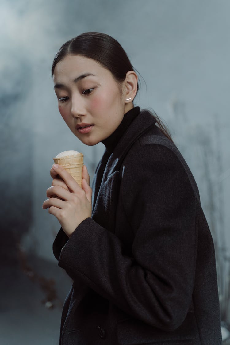 Woman In Black Coat Holding An Ice Cream Cone