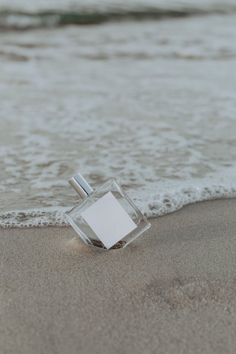 A Bottle Of Perfume In The Sand 