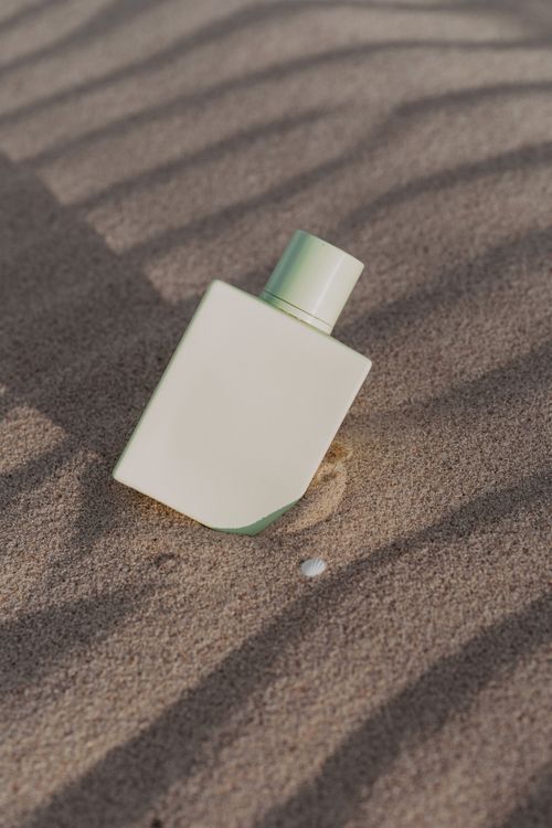 Free Elegant minimalist perfume bottle set against textured sand background. Stock Photo