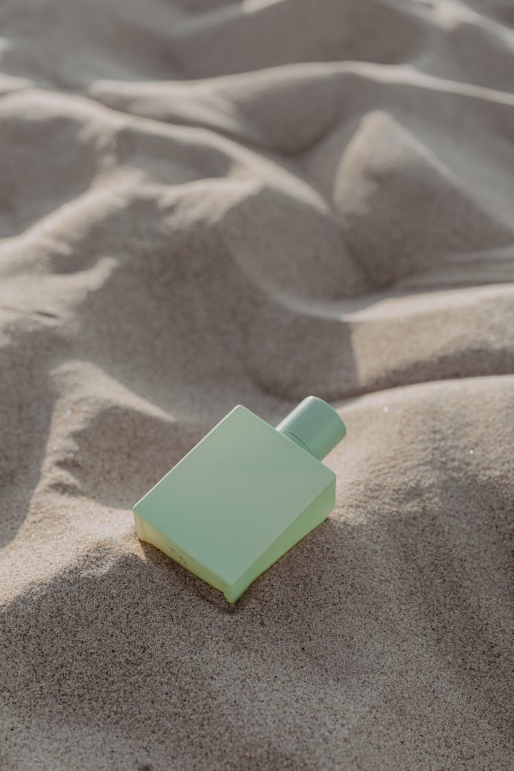 Green Square Perfume Bottle On Sand