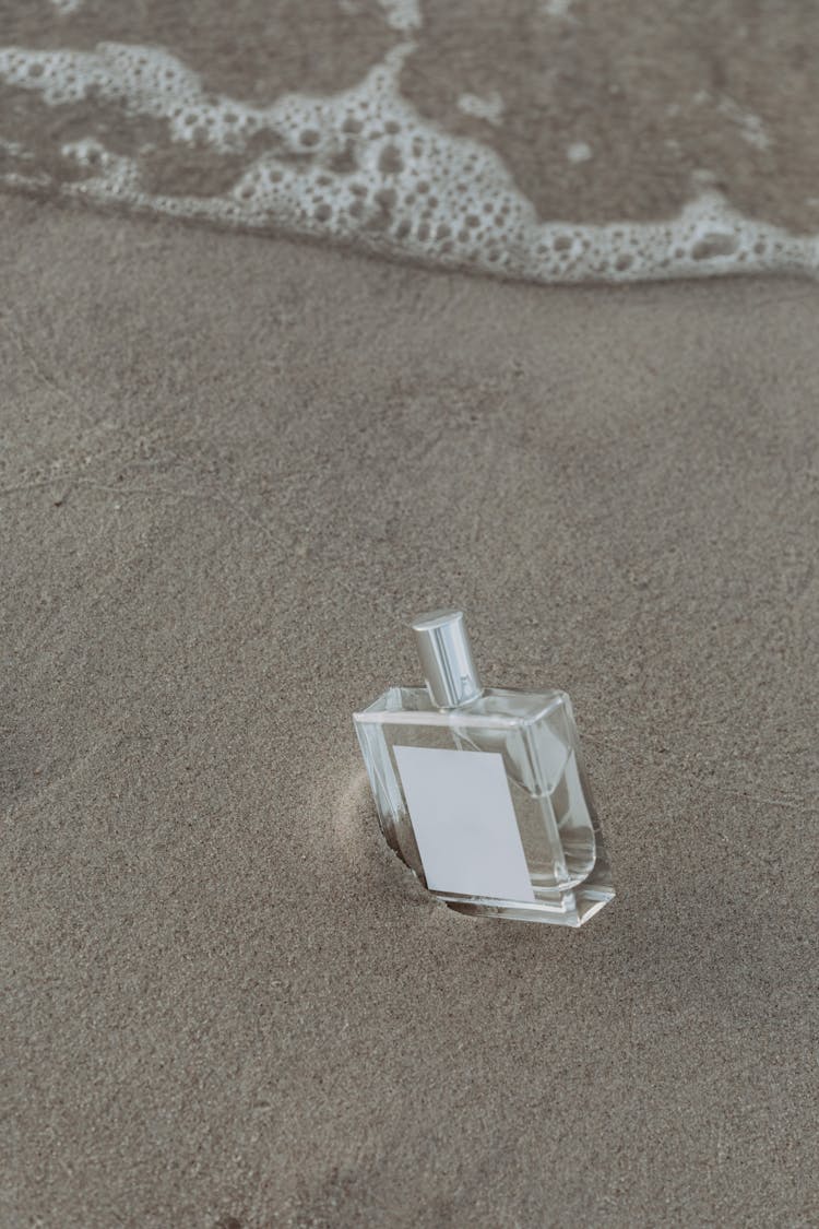 Clear Glass Perfume Bottle On Seashore 