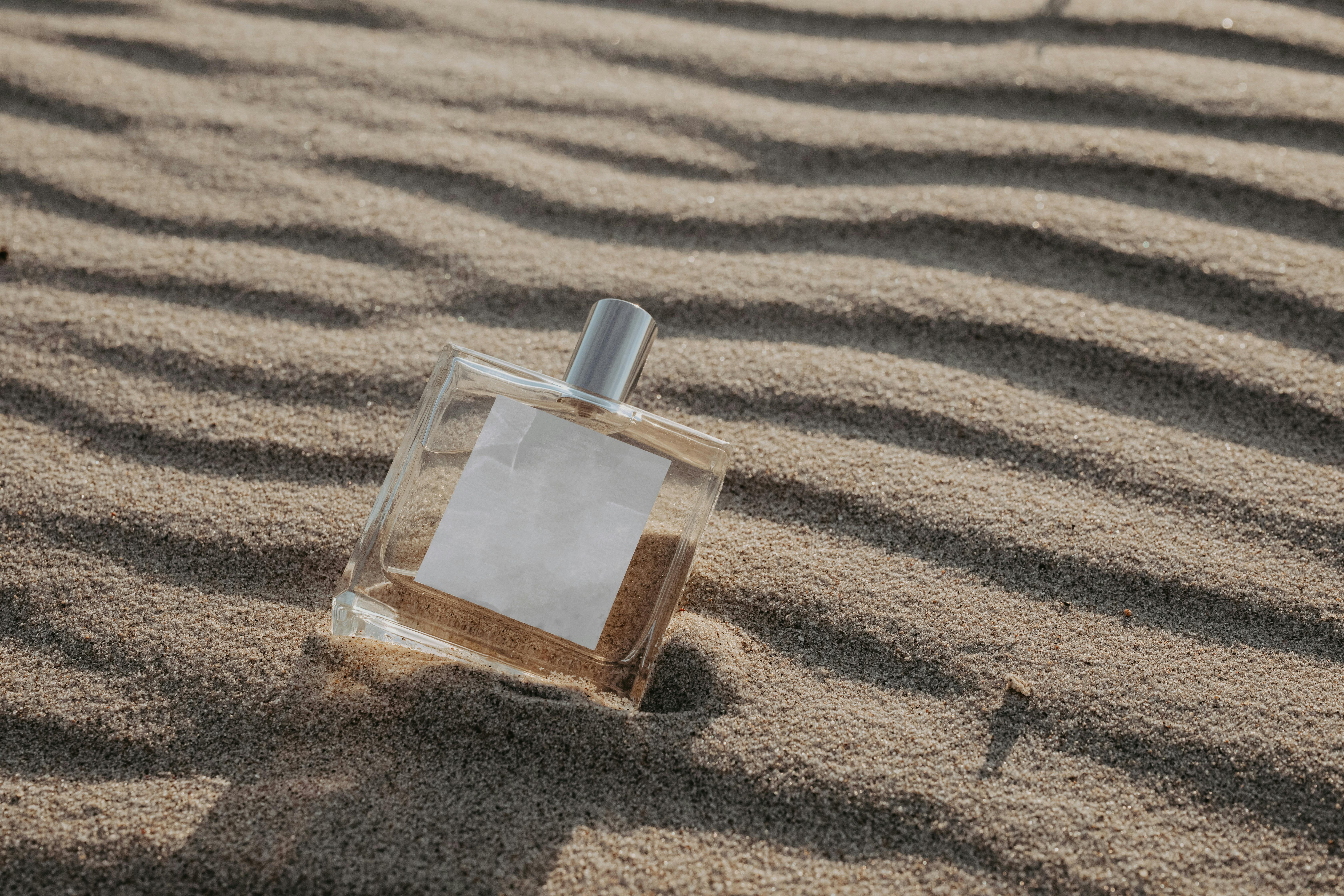 Close-Up Shot of a Perfume Bottle on the Sand