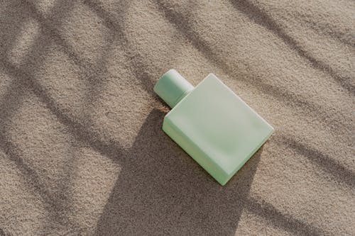 Close Up Shot of a Perfume Bottle on the Sand