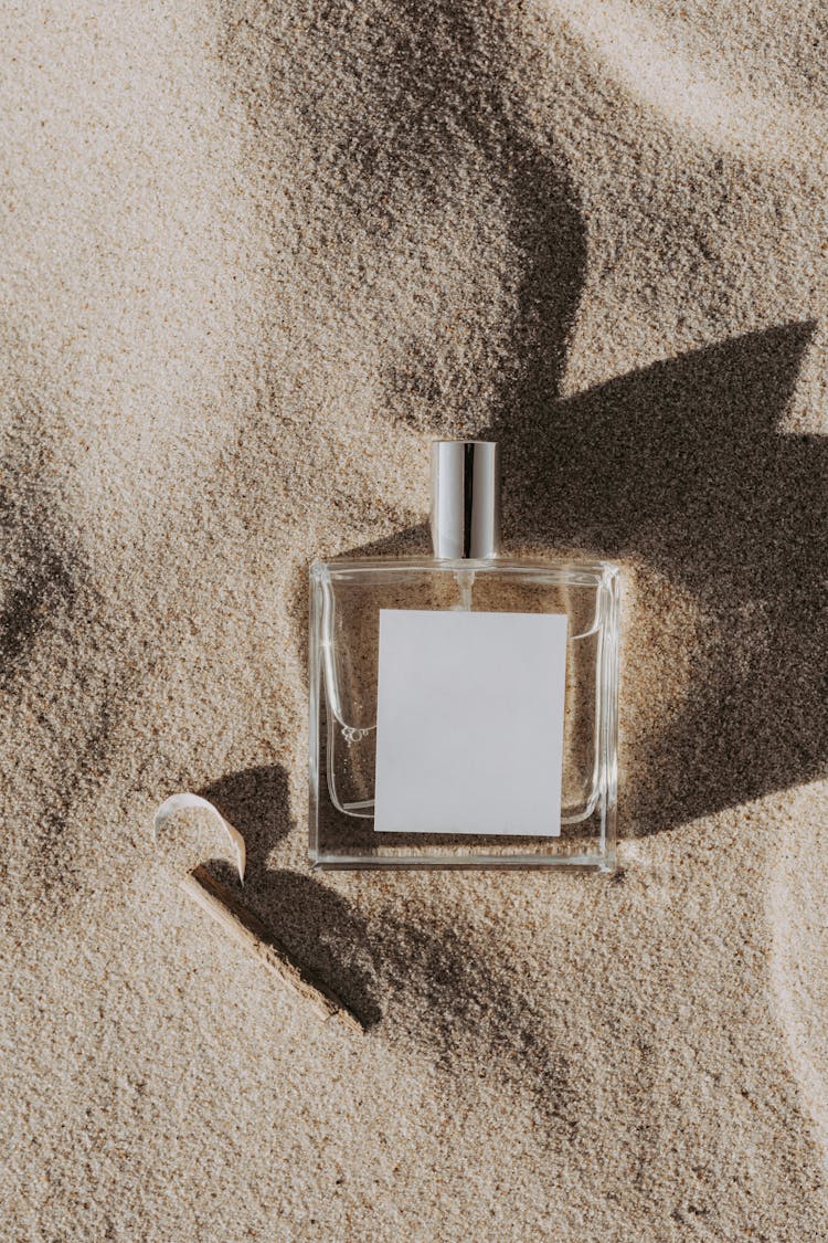 Close-Up Shot Of A Perfume Bottle On The Sand