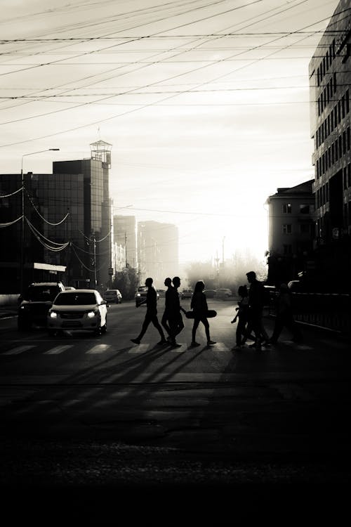 Grayscale Photo of People Crossing the Street in a City