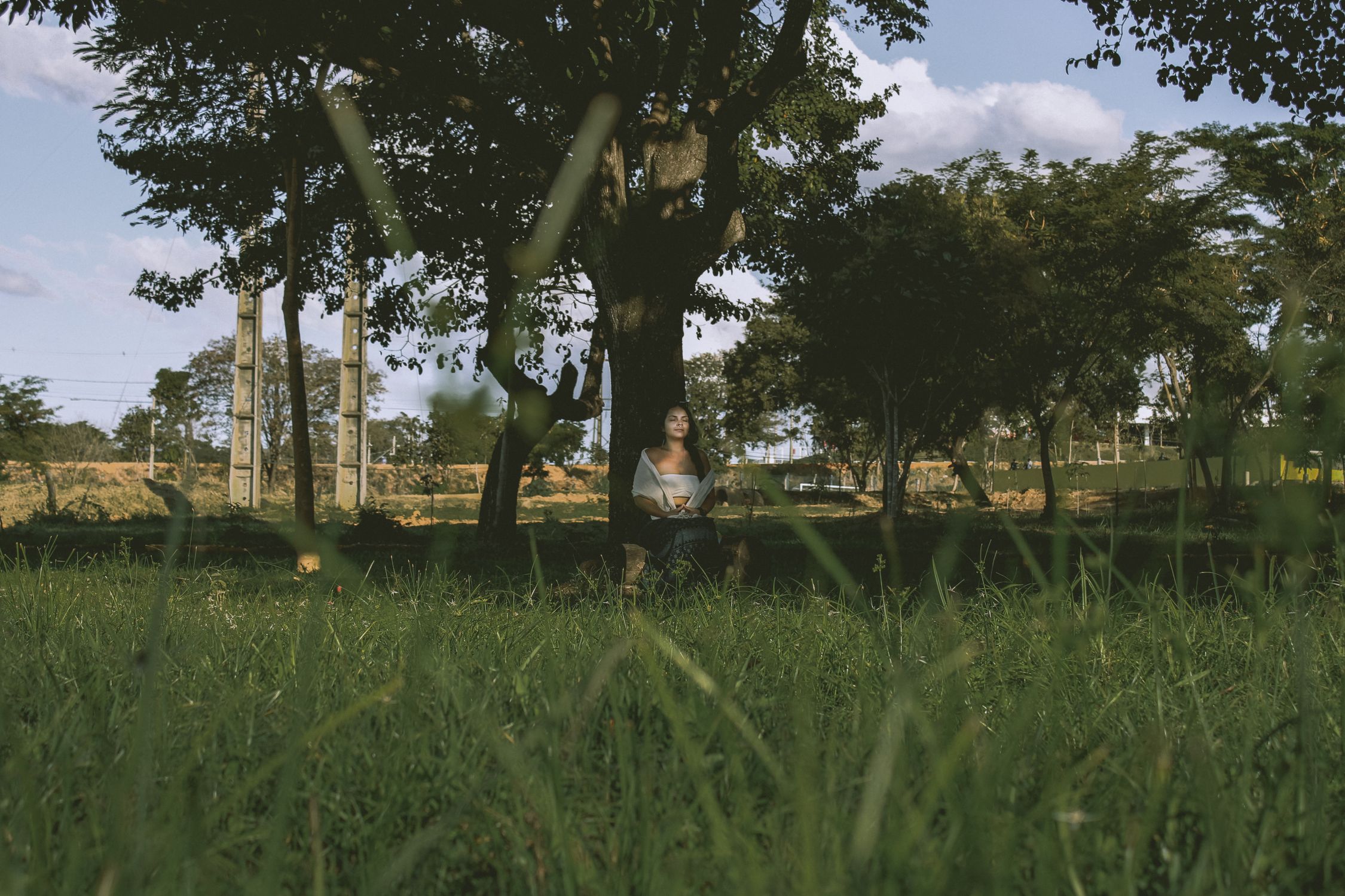 Mulher relaxando na natureza ao ar livre, representando o distanciamento saudável das redes sociais e a recuperação do foco