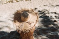 戴着草帽的人在沙滩上享受日光浴，体现了暑假的氛围