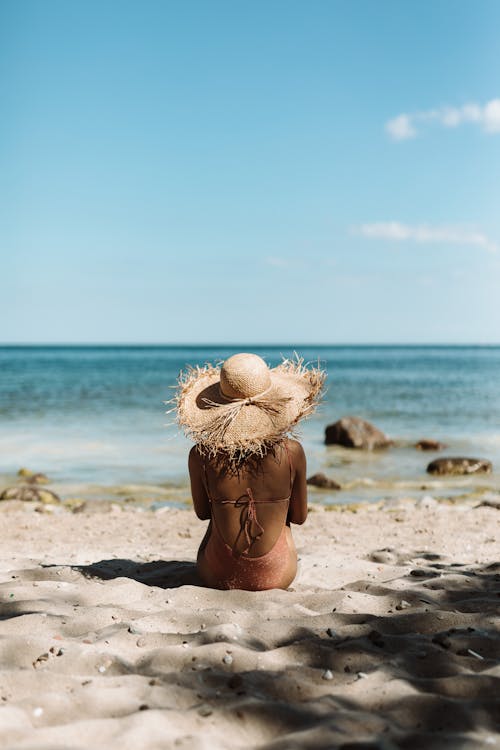 A Woman Wearing a Straw Hat at the Beach 
