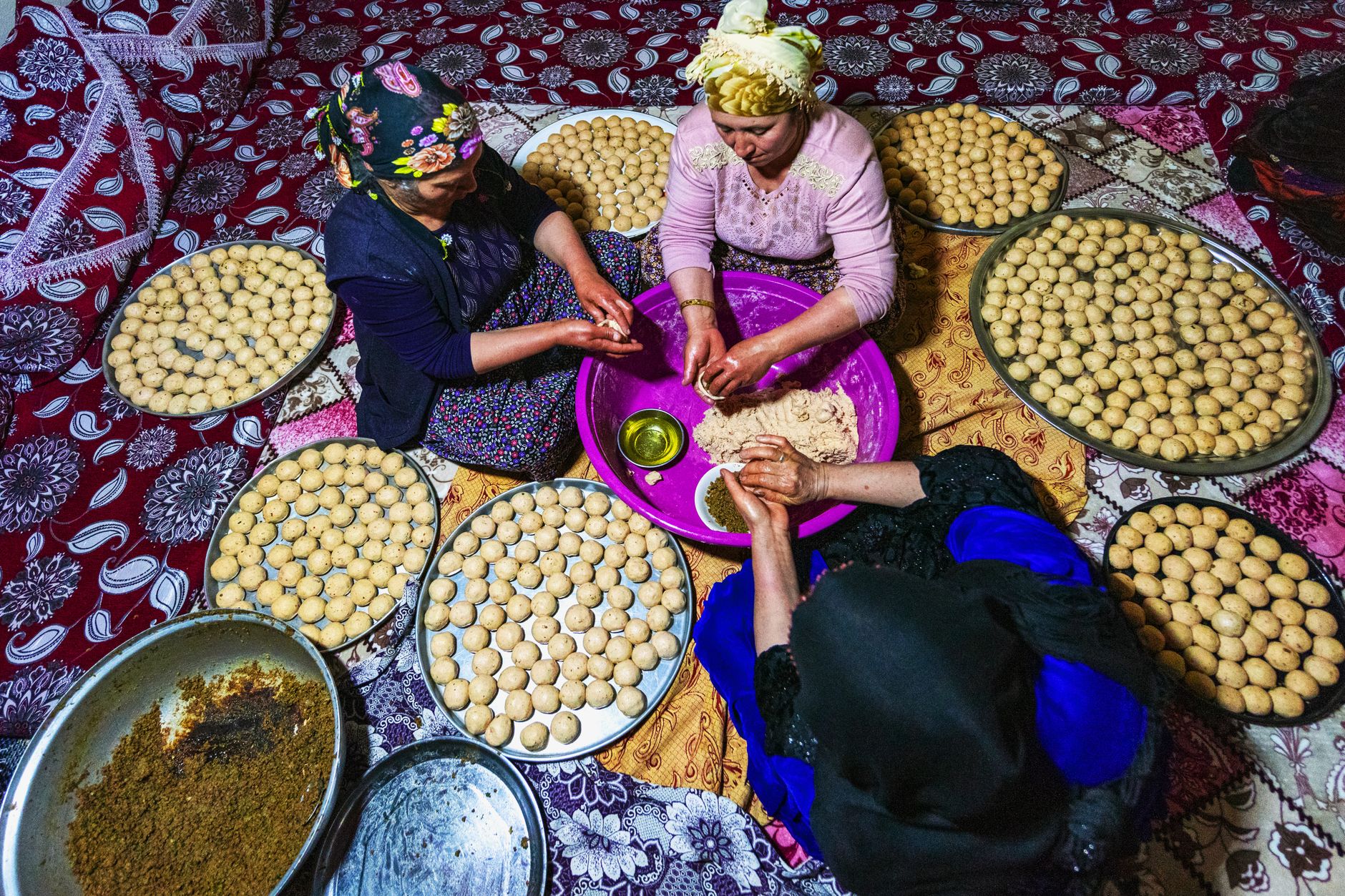 Women collaboratively preparing traditional bread, showcasing culture and teamwork.
