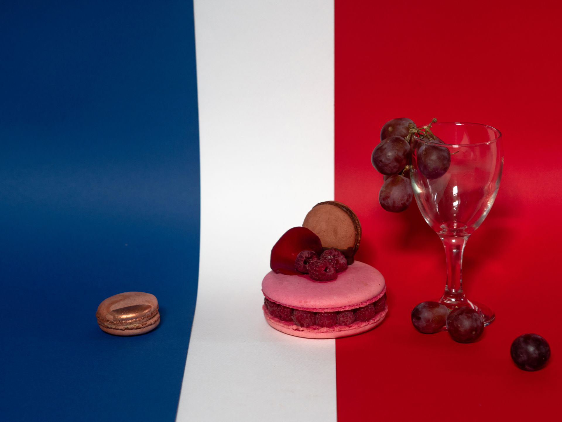 Macaroons, Grapes and a Wine Glass on a French Flag Background