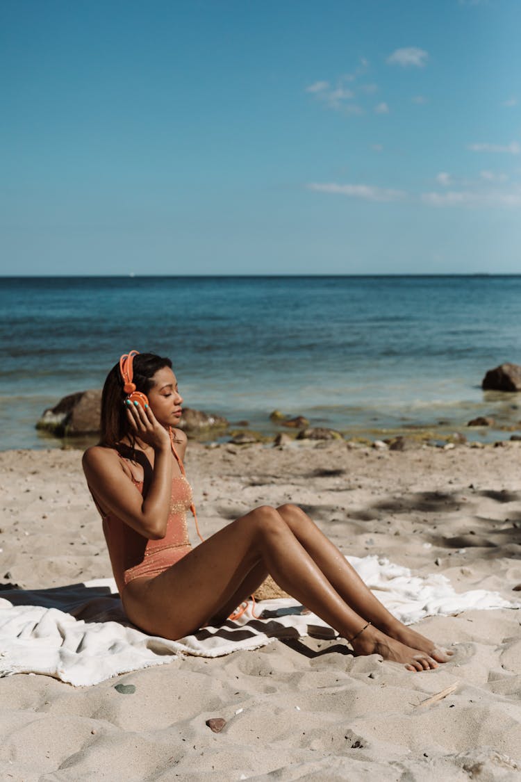 A Woman Listening To Music At The Beach 