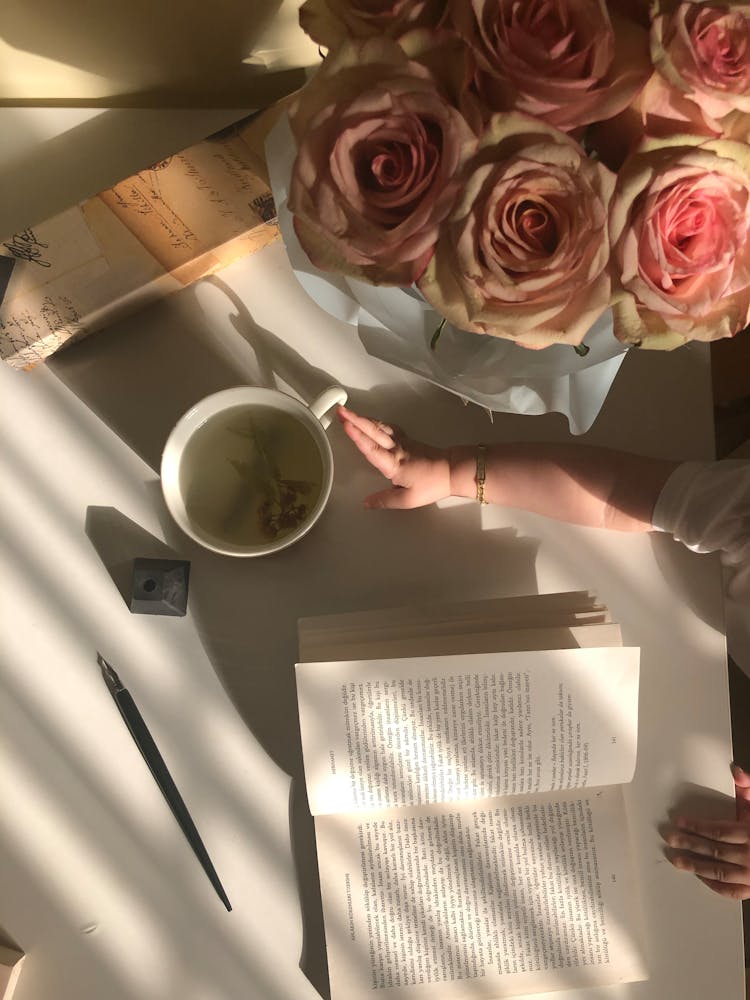 A Baby's Hand Reaching For A Cup Of Tea