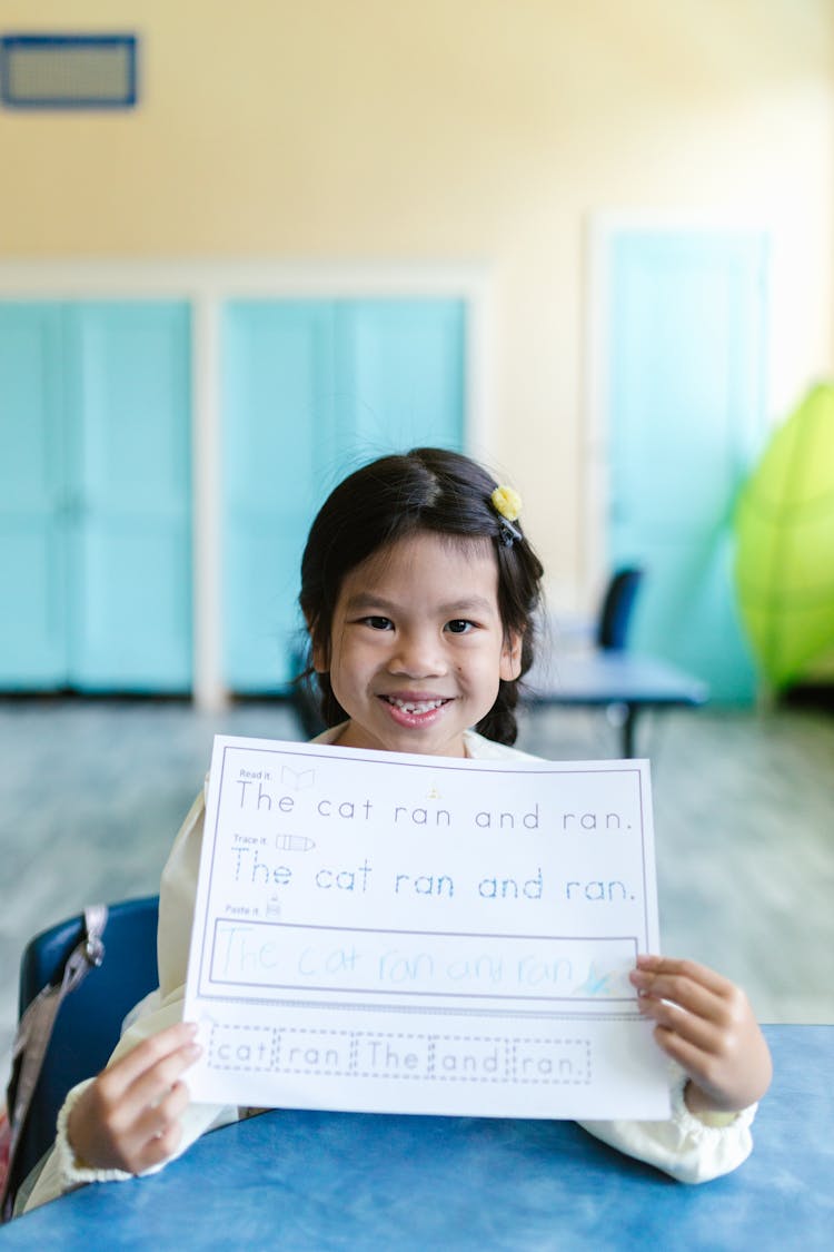 Girl Smiling While Holding Her Worksheet