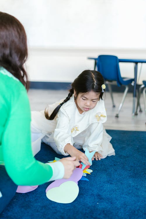 A Kid Playing with Cutout Toys at the School